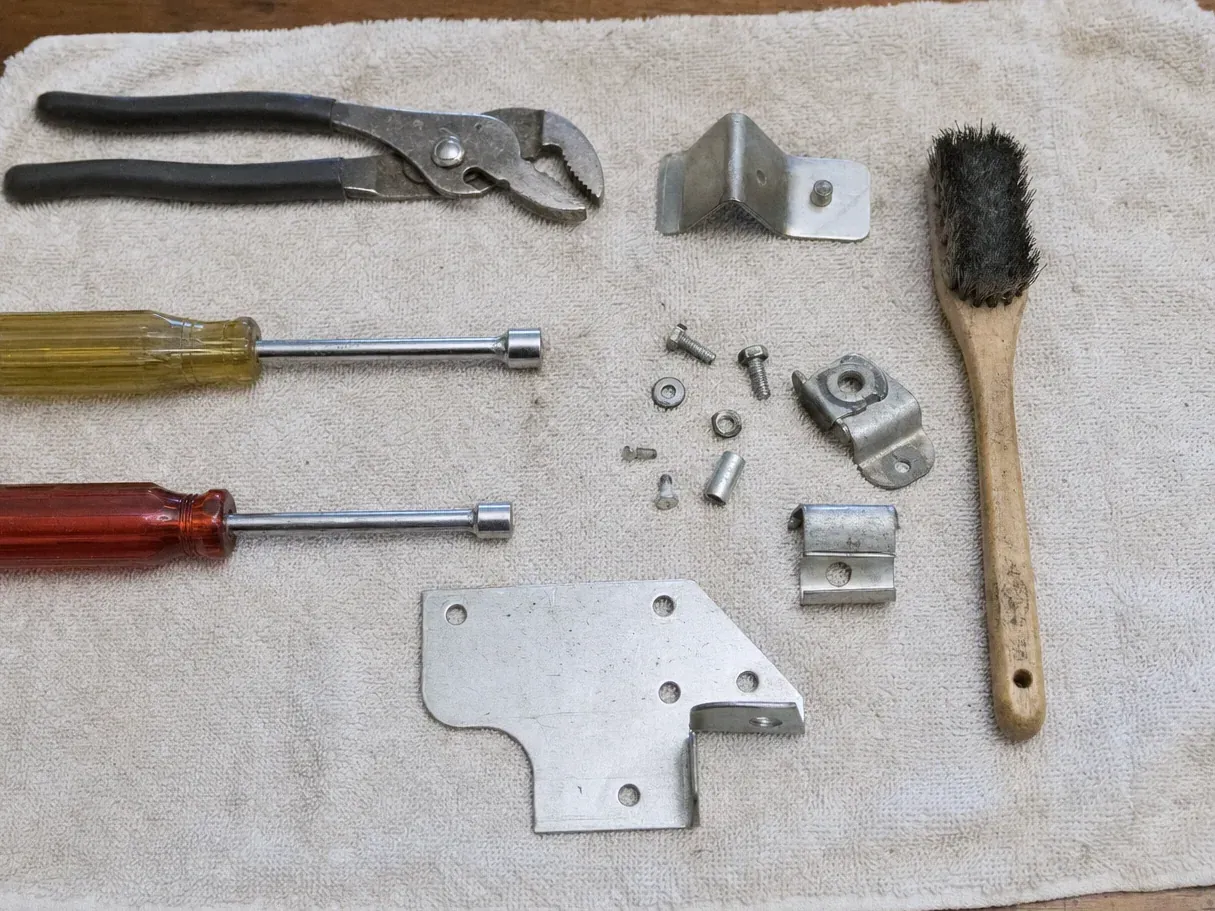 Wooden brush, groove-joint pliers, nut drivers and metal brackets