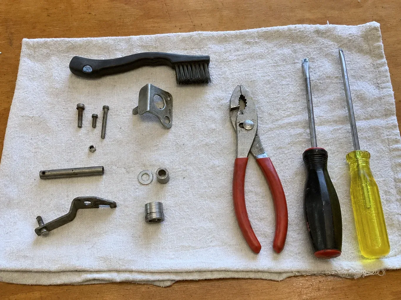 Two screwdrivers, pliers, brush and small metal parts