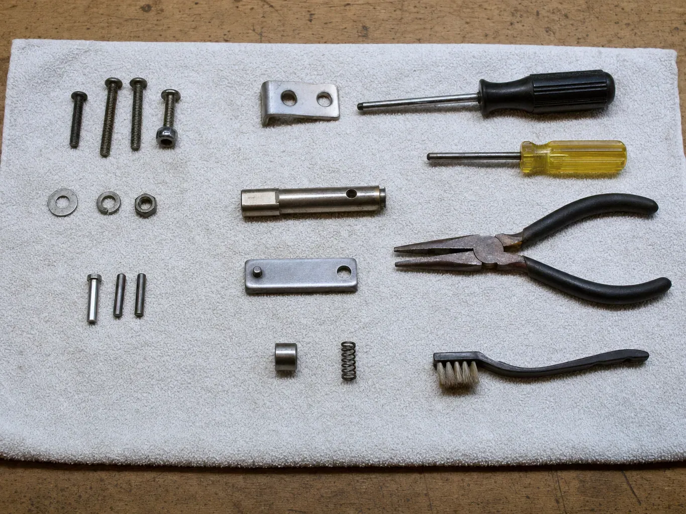 Two screwdrivers, pliers, brush, metal plates, screws and pins