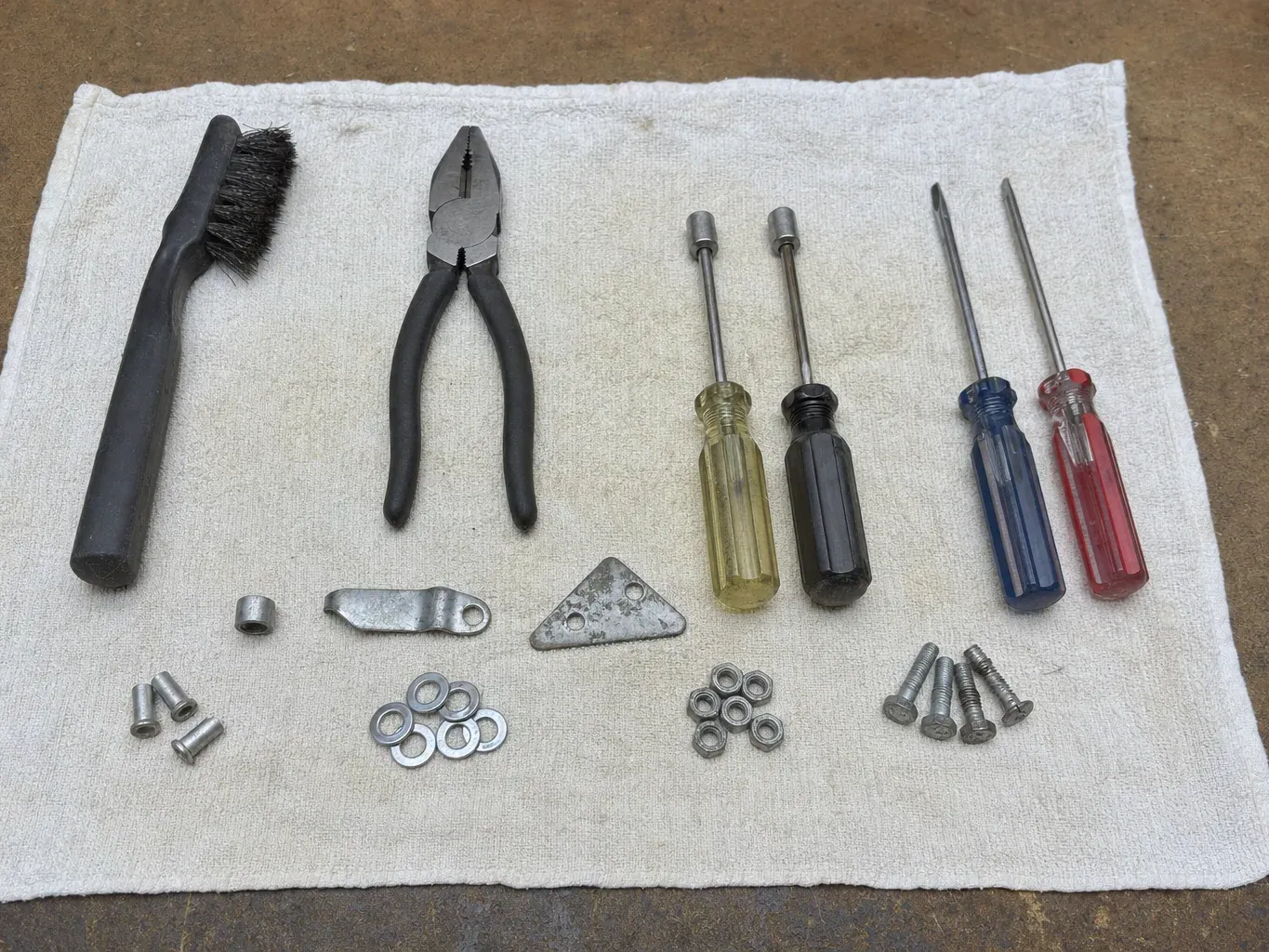 Four screwdrivers, pliers, brush, bolts, nuts and washers
