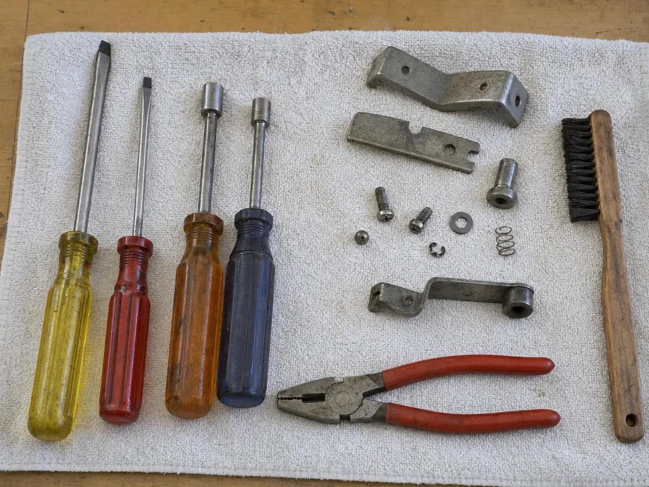Wire brush, pliers, screwdrivers and metal linkage parts