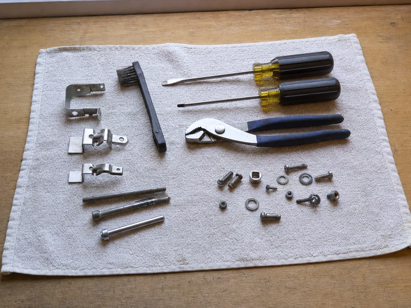 Two screwdrivers, groove pliers, brush, brackets, bolts and long pins